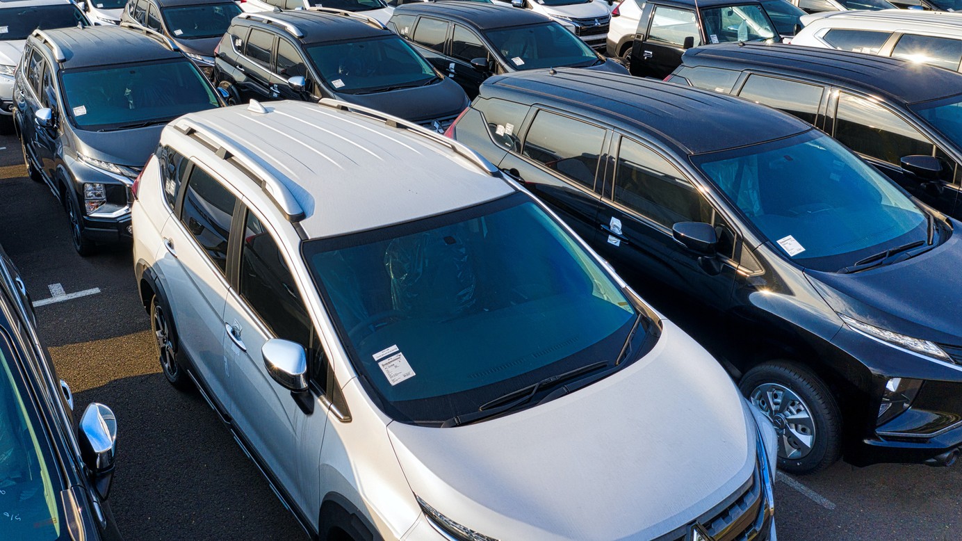 Several cars parked next to each other in several rows