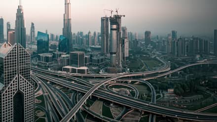 A skyline of a large modern city with a network of highways