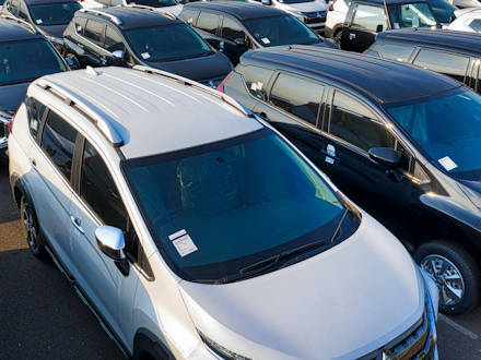 Several cars parked next to each other in several rows